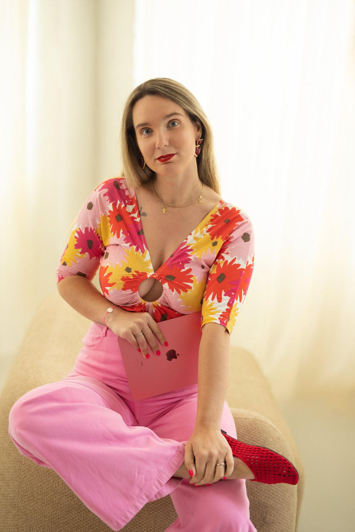 Marie Cotrel, community manager et photographe à Lyon, assise avec une tablette rose